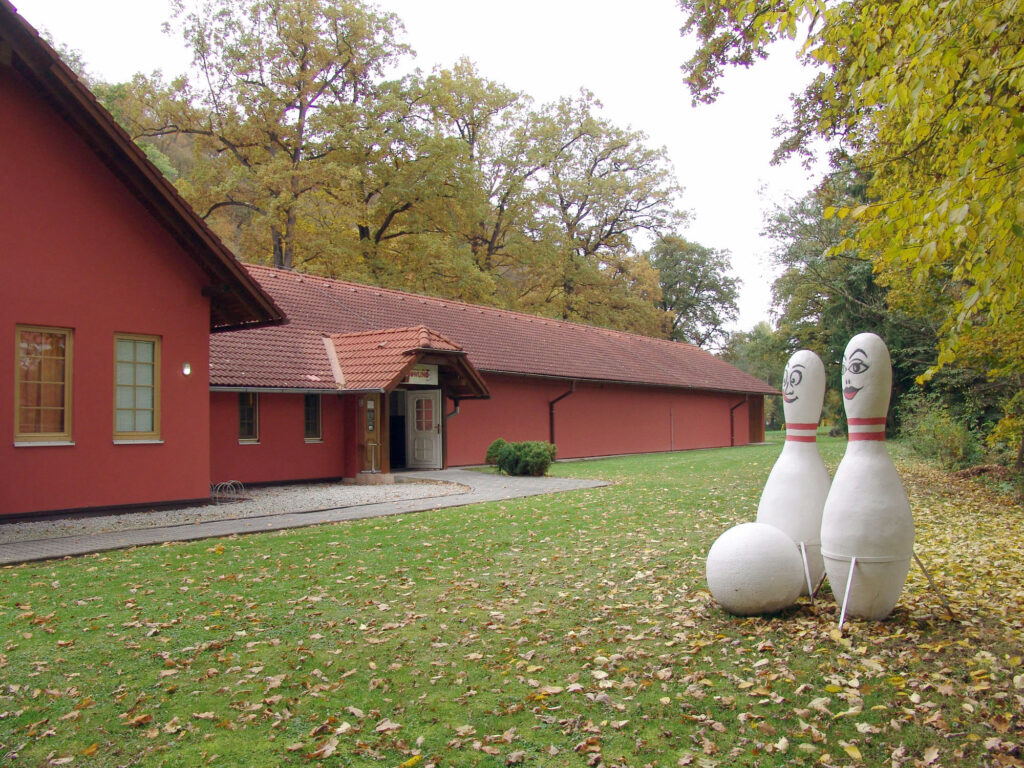 Budova Bowlingu Hluboká s kuželkami před vchodem