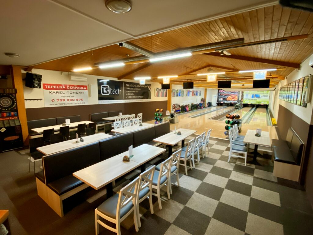 Interiér herny se sezením a bowlingovými drahami